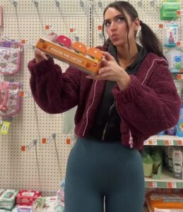 Woman in Dollar Tree holding viral beauty products.