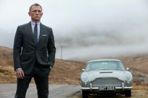 Daniel Craig as James Bond in a suit, standing in front of a classic car.