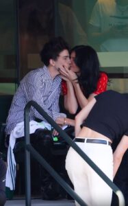 Kylie Jenner and Timothée Chalamet kissing at a tennis match.