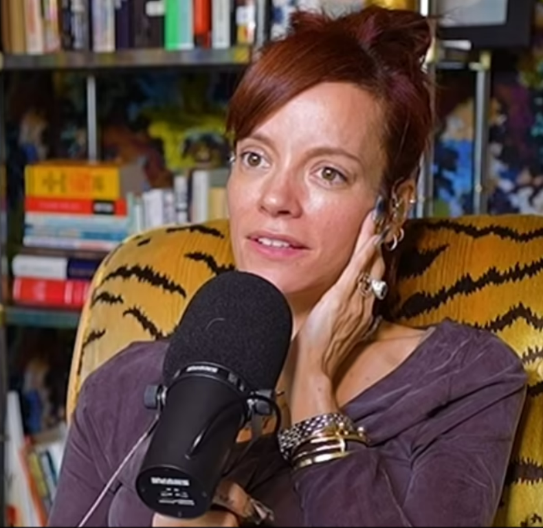 Lily Allen in an interview, speaking into a microphone.