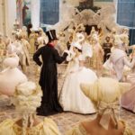 Snow White and the Prince meet in a ballroom, where everyone is dressed in an over-the-top ballgown styled like an animal. Everything is in shades of white and cream, except for the Prince, who wears a black suit and tophat with rabbit ears. Snow White’s dress is styled like a swan, complete with a swan hat. From Mirror Mirror.