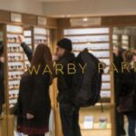 view of shoppers in Warby Parker through a storefront window