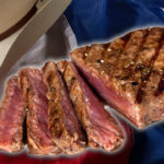 NY strip steak shown over Texas flag