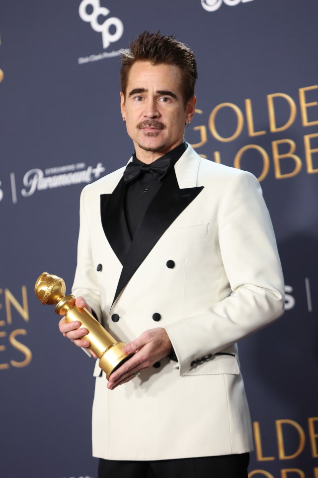 Colin Farrell holding a Golden Globe award.