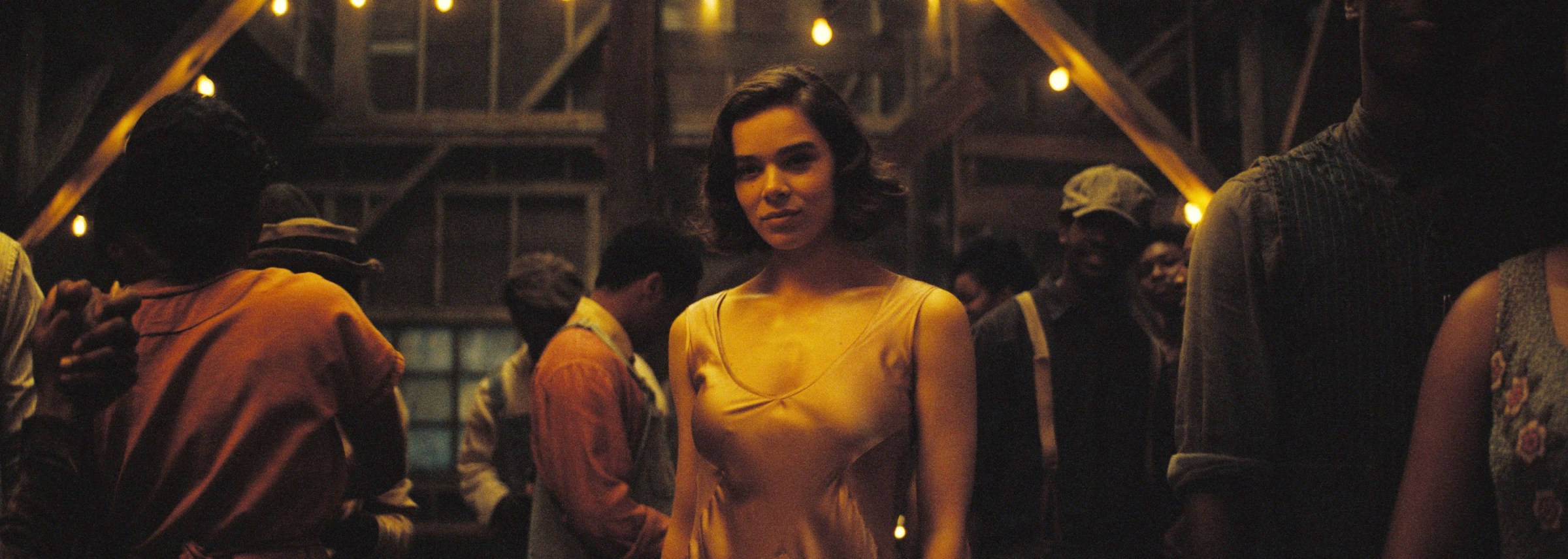 Mary (Hailee Steinfeld) stands smiling in a thin silk dress in a rural 1932 juke joint in Ryan Coogler’s Sinners