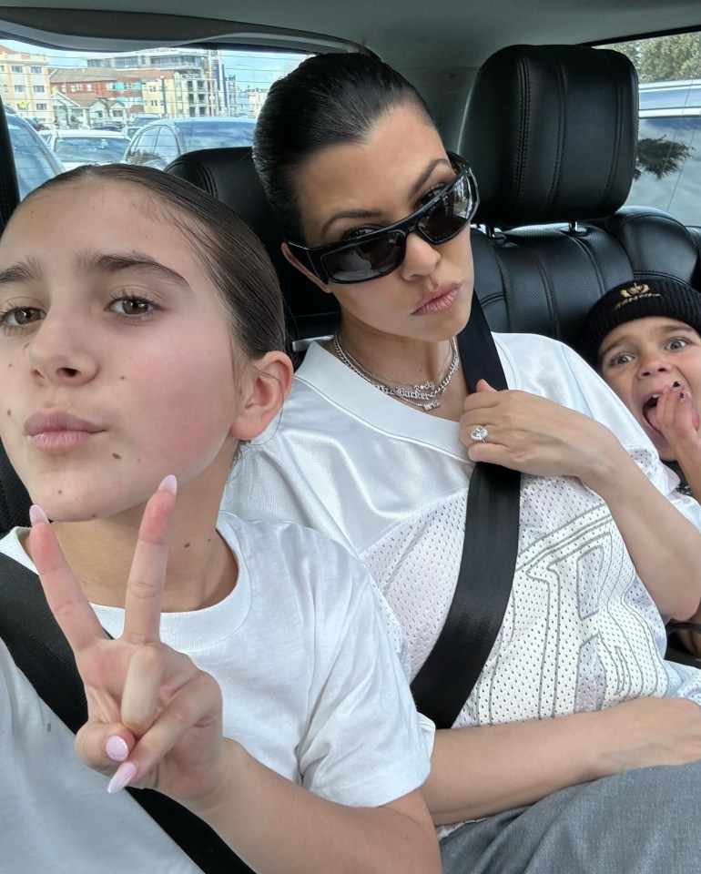 Kourtney Kardashian with two children in a car.