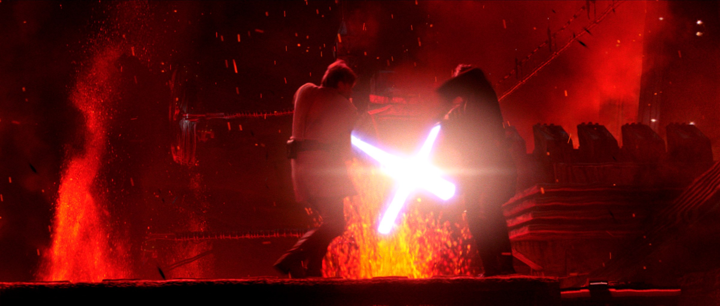 Anakin (Hayden Christensen) and Obi-Wan lock lightsabers on Mustafar, surrounded by red light and burning lava, in Star Wars: Episode III — Revenge of the Sith