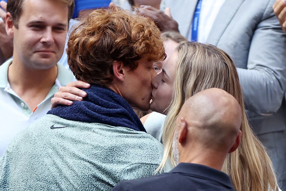 Jannik Sinner kissing his girlfriend after winning a tennis match.