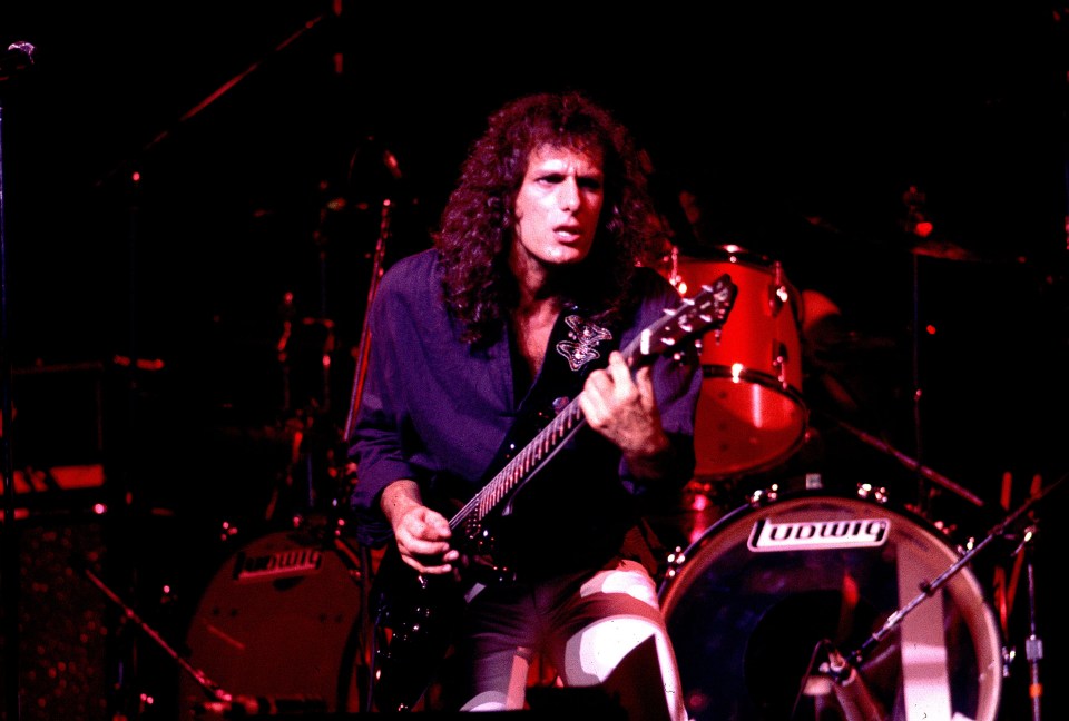 Michael Bolton playing guitar on stage.