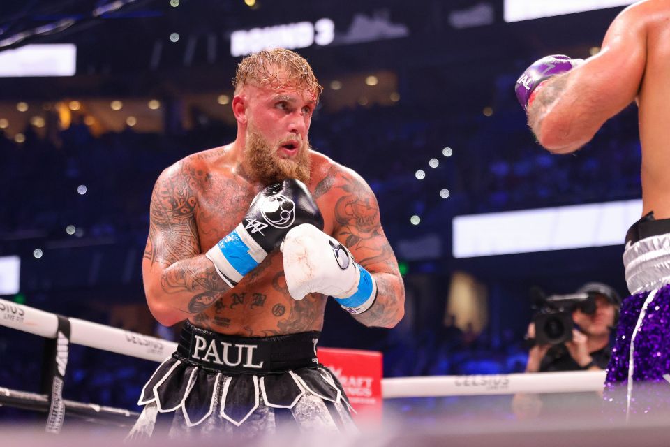 a man in boxing gloves has the name paul on his shorts