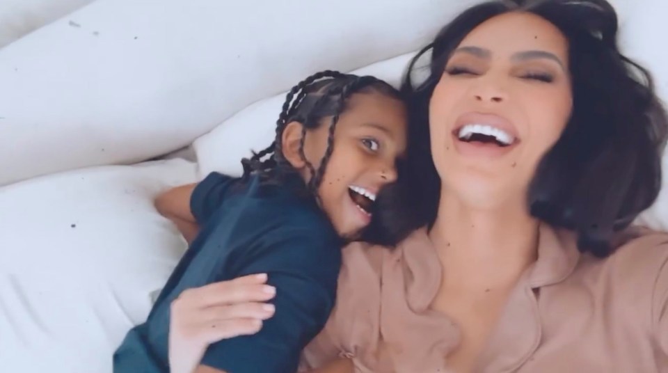 Kim Kardashian and her son Saint West laughing together in bed.