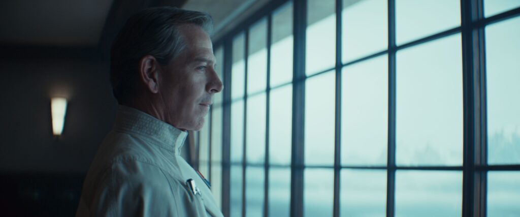 Orson Krennic played by Ben Mendelsohn stands looking out a window in Andor season 2