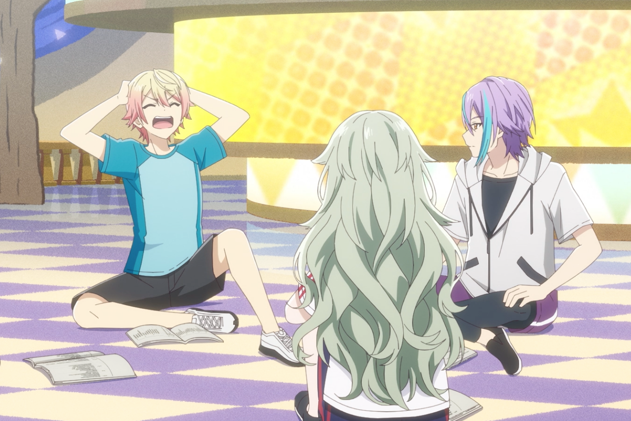 A group of four teenagers sit on the floor of a colorful checkerboard stage in a theme park, with one blonde-and-pink-haired boy in a blue shirt clutching his head and yelling. From Colorful Stage! The Movie: A Miku Who Can’t Sing