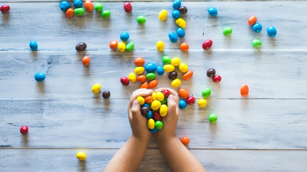 A photo of a child holding peanut M&Ms.