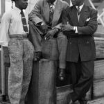 Three Jamaican immigrants (left to right) John Hazel, a 21-year-old boxer, Harold Wilmot, 32, and John Richards, a 22-year-old carpenter, arriving at Tilbury on board the ex-troopship 'Empire Windrush', smartly dressed in zoot suits and trilby hats. (Photo by Douglas Miller/Keystone/Hulton Archive/Getty Images)