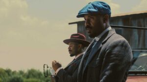 imax image from sinners movie of smoke and stack sitting on a car