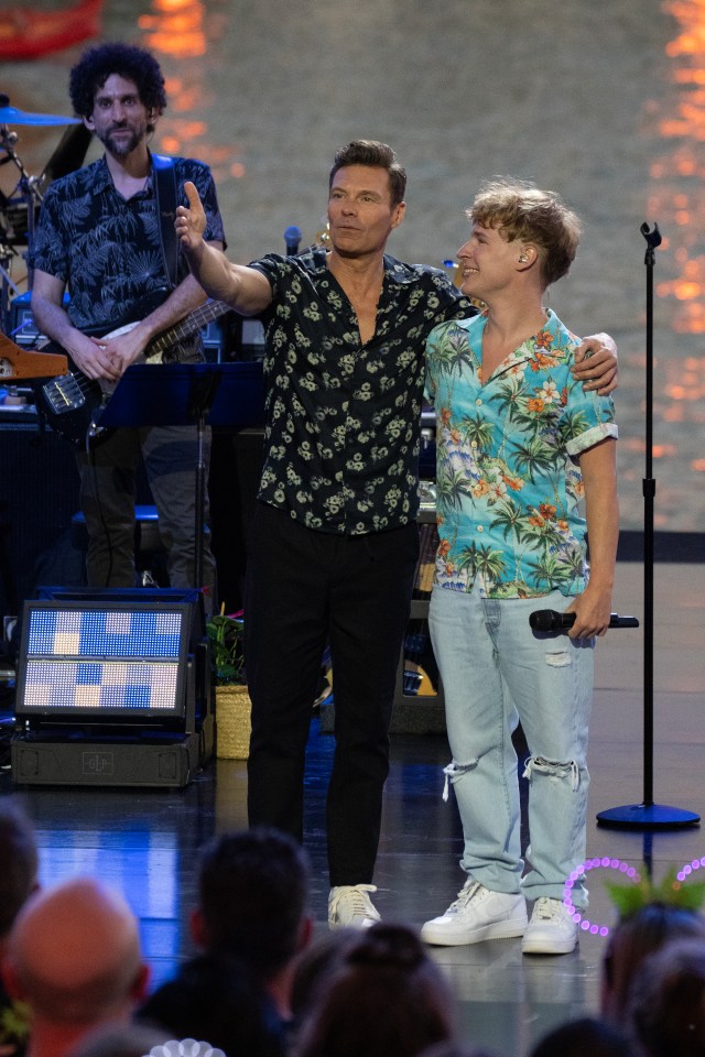 Two men in floral shirts on stage at the Aulani Disney Resort.