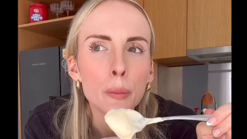 Woman tasting creamy sauce.
