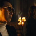 Caine in sunglasses sits in a church with John Wick opposite him in John Wick: Chapter 4
