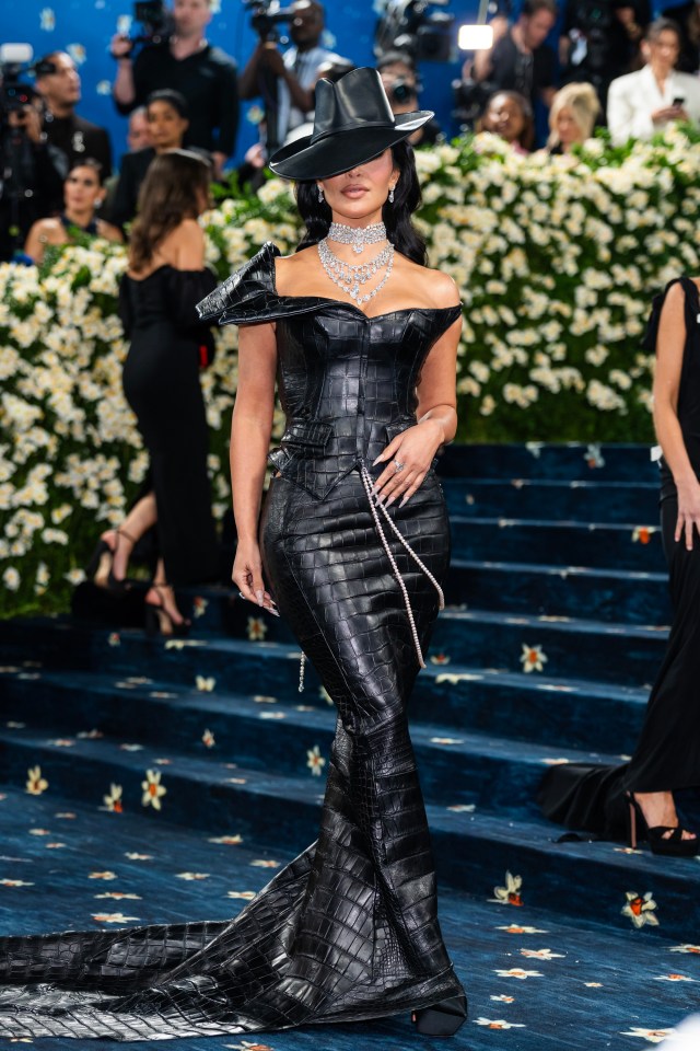 Kim Kardashian at the Met Gala in a black crocodile-skin gown and hat.