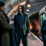 The Bowery King presents John Wick with a suit in a train station as Winston looks on in Chapter 4