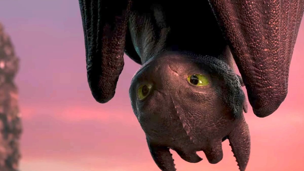 An upside down Toothless against a setting sun sky in the live-action How to Train Your Dragon