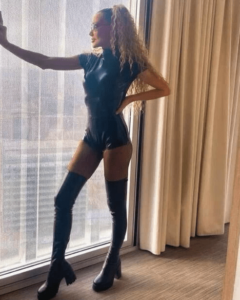 Whigfield, 90s pop star, in a black bodysuit and boots.
