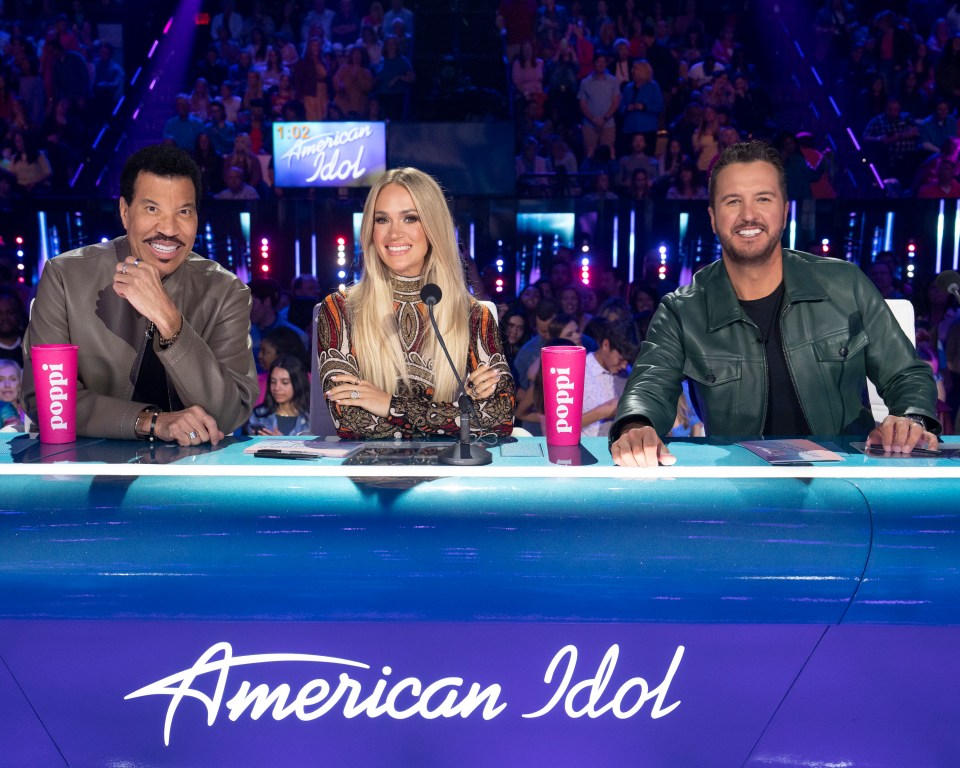American Idol judges Lionel Richie, Carrie Underwood, and Luke Bryan at the judges' table.