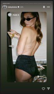 Hailey Bieber's Instagram story: topless photo, back tattoo, and martini.