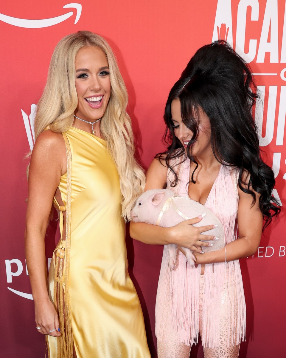 Megan Maroney and Jessie Murph at the Academy of Country Music Awards holding a pig.