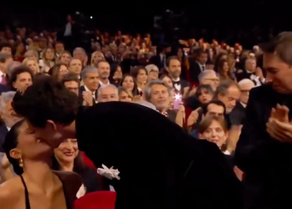 Kylie Jenner and Timothée Chalamet kissing in an audience.