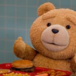 Ted giving thumbs up in front of a tray of food in a cafeteria
