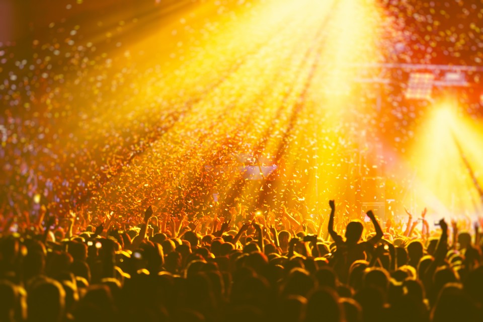 Crowd at a concert with confetti falling.