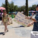 A zoo attendee passes by animal rights activist demonstrator in front of the Los Angeles Zoo.