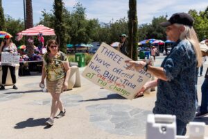 A zoo attendee passes by animal rights activist demonstrator in front of the Los Angeles Zoo.