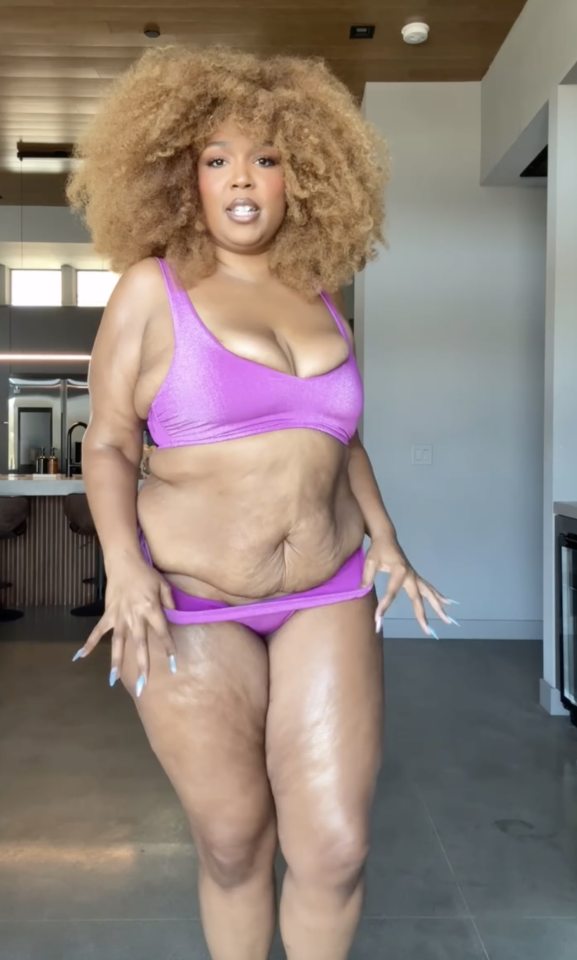 Lizzo in a purple swimsuit.