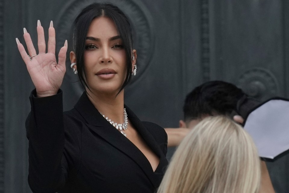 Kim Kardashian waving while arriving to testify about a 2016 robbery.