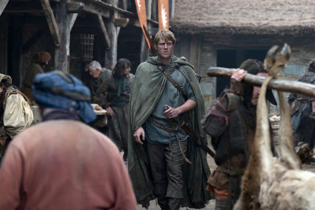Ser Duncan the Tall in raggedy clothes walks through a market in A Knight of the Seven Kingdoms