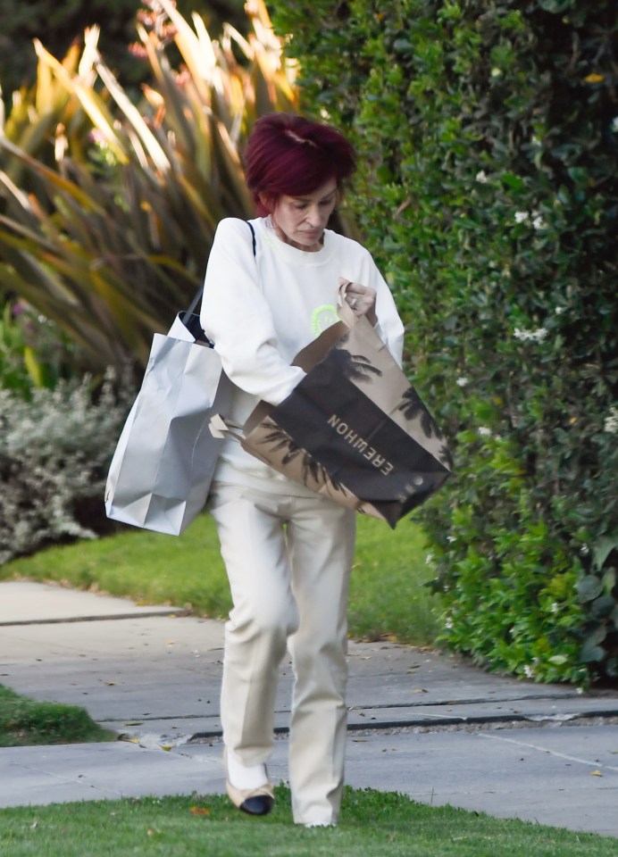 Sharon Osbourne carrying shopping bags while walking.