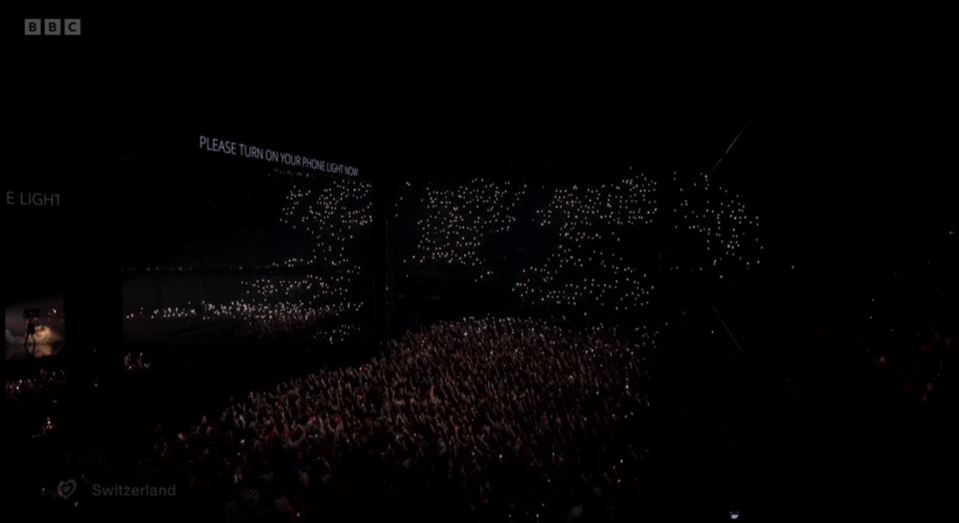 Concert audience with lit-up phones.