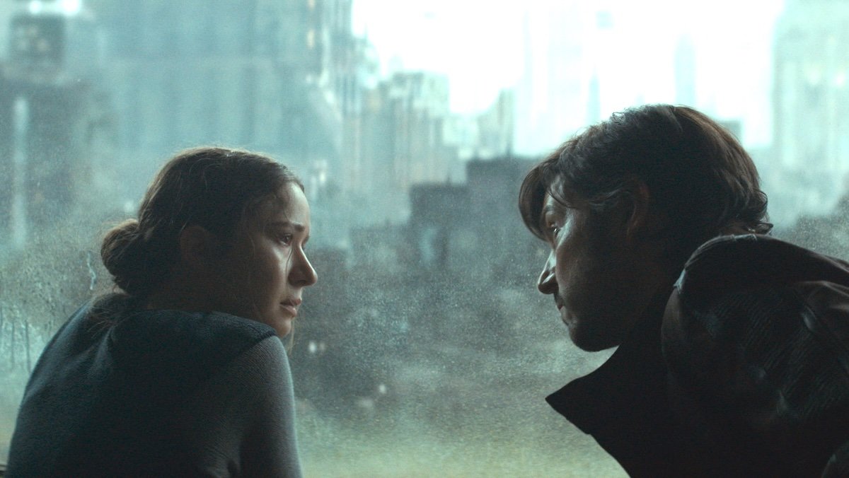 Kleya and Cassian Andor speak near a window as it rains outside