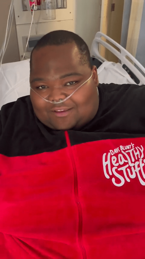 Dave Blunt in a hospital bed, taking a break from touring to focus on his health.