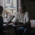 A woman and a man seated at a diner table.