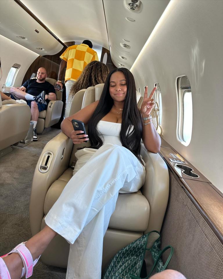 Woman on private jet making peace sign.