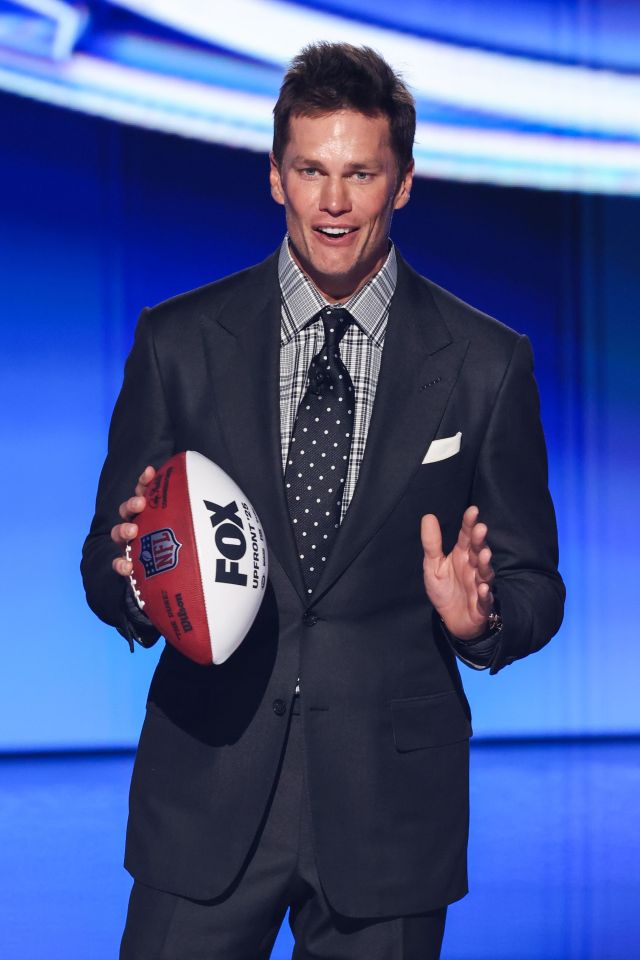 Tom Brady holding a football at the FOX Upfront presentation.