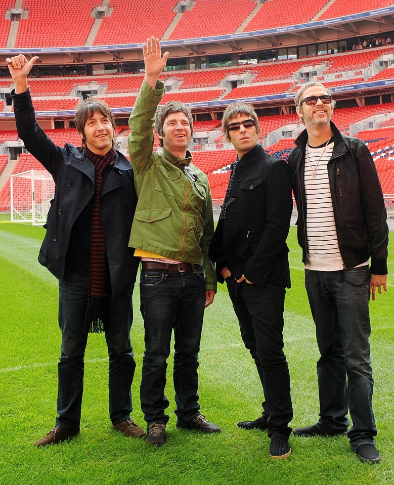 Oasis band members posing at Wembley Stadium.