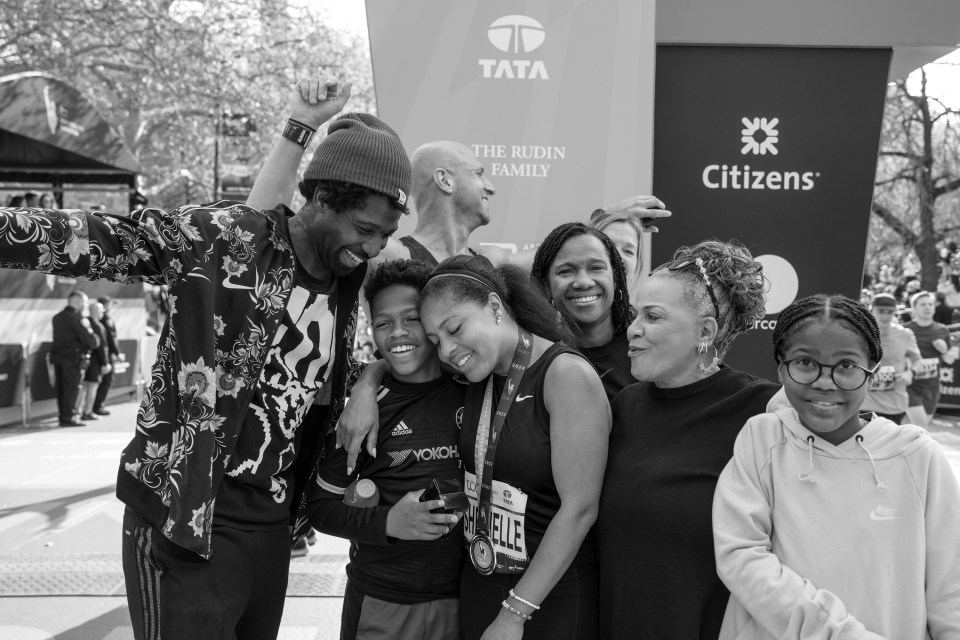 Black and white photo of Sheinelle Jones and her family after she completed the 2023 TCS New York City Marathon.