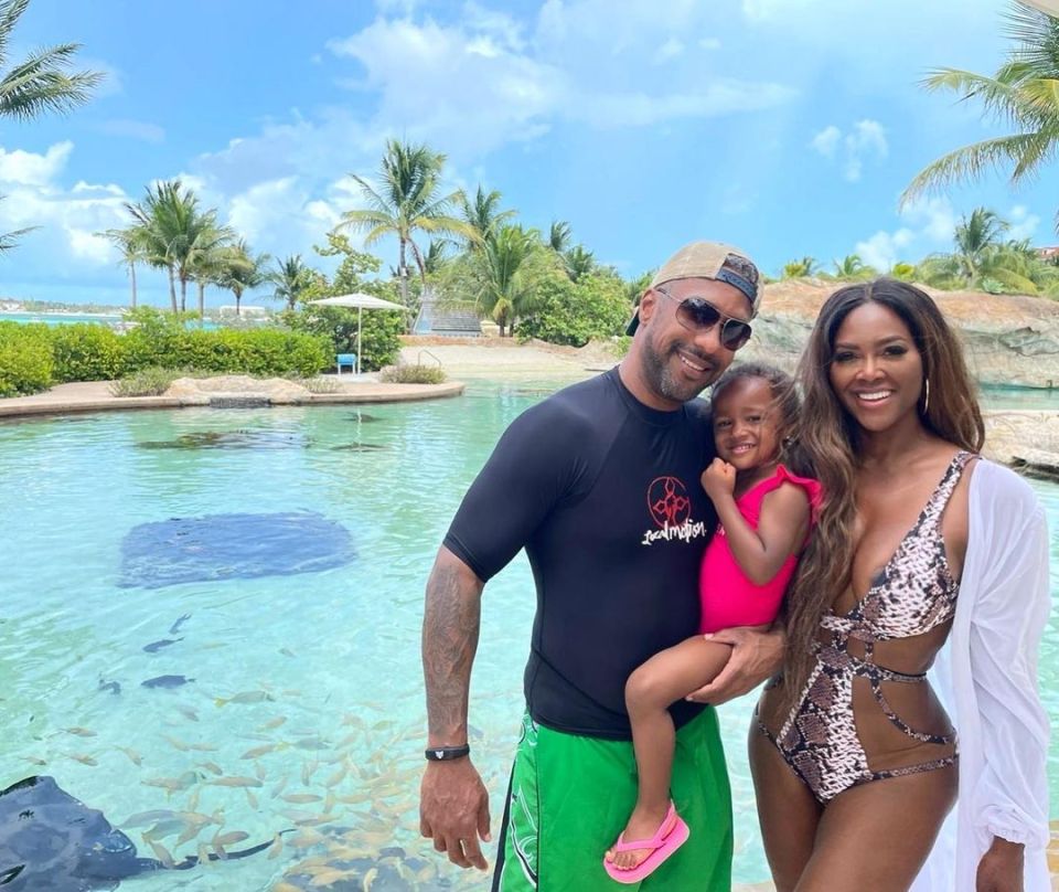 Family posing by a pool with fish.