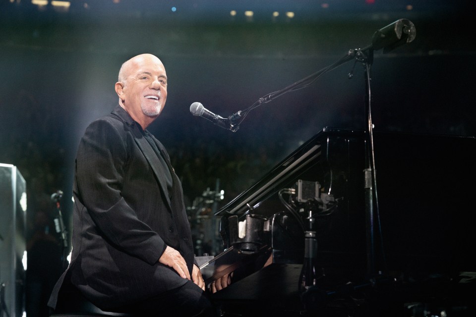 Billy Joel performing at a piano.