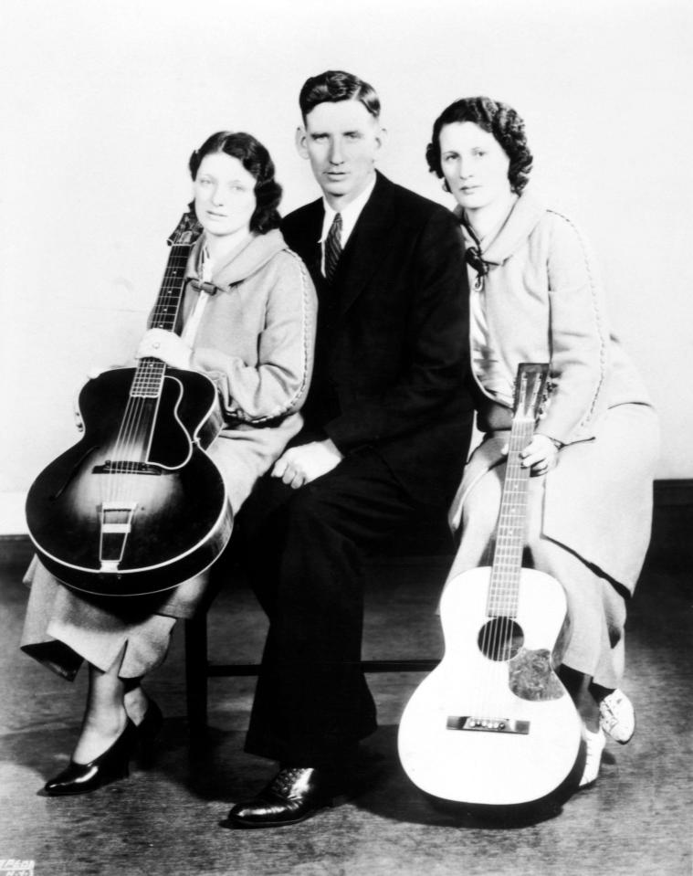 Black and white photo of Maybelle Addington Carter, Alvin Pleasant Delaney Carter, and Sara Dougherty Carter, the Carter Family, posing with guitars.